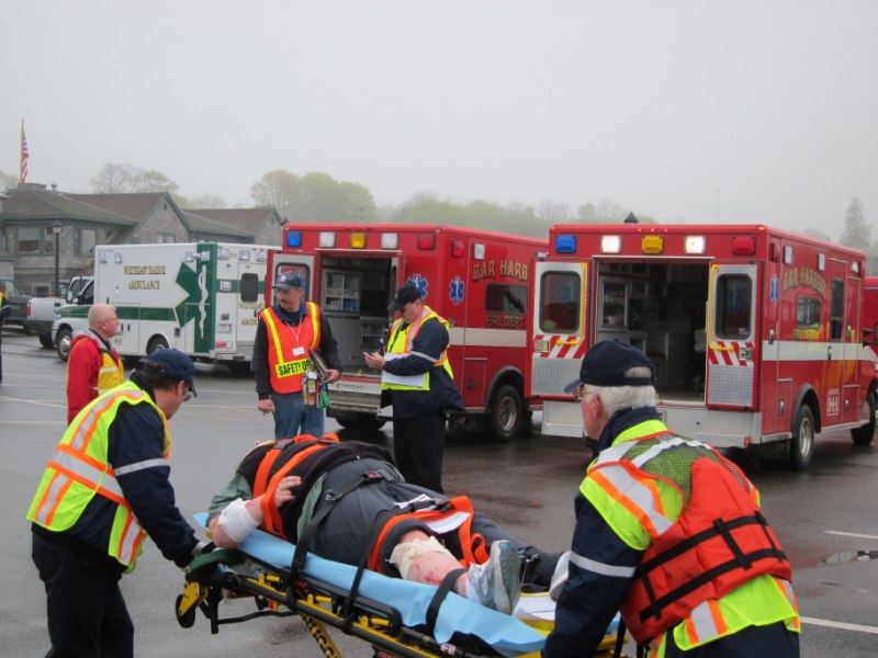 Local EMS crews load a patient into one of three ambulances 