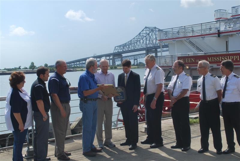 Officials with the Port of New Orleans Cruise Division conduct a plaque exchange with American Cruise Lines executives to commemorate the inaugural cruise of the "Queen of the Mississippi." Pictured is (left to right) Sharon Reames, Port of New Orleans; Steven Gauthier, Port of New Orleans; Johnny Cefalu, Deputy Director of Cruise and Tourism, Port of New Orleans; Robert Jumonville, Port of New Orleans Director of Cruise and Tourism; Charles Robertson, Chairman & CEO of American Cruise Lines; Paul Taiclet, VP & Hotel Operations - ACL; Capt. John Ayer; Capt. Kenny Williams; Capt. Mike Snyler; and Capt. John Keereweer. 