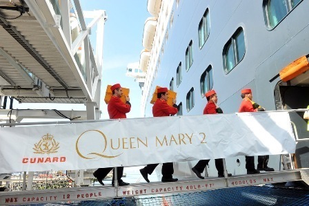 Cunard's White Star Bellmen carry cases of Veuve Clicquot champagne aboard Queen Mary 2 for Royal Wedding commemorative cocktails during the ship's Transatlantic Crossing, which embarked from New York on Thursday, 26 April.