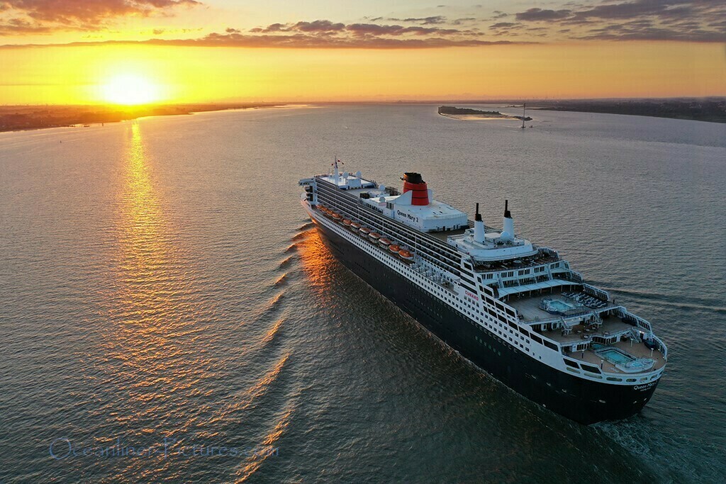 Queen Mary 2 cruising on the Elbe river at sunset